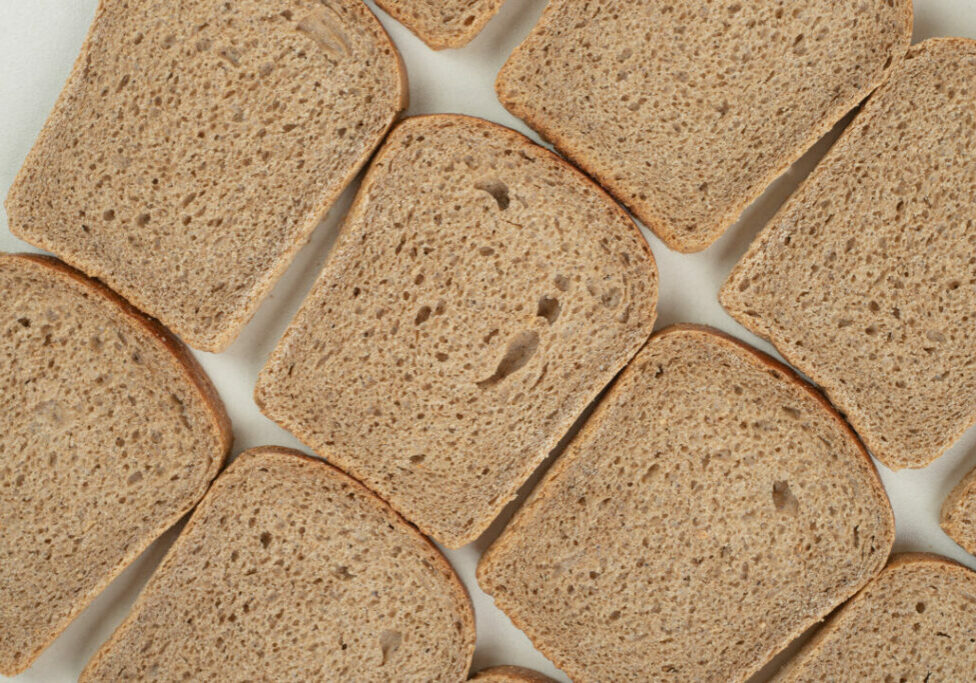 Sliced fresh brown bread on white background. High quality photo